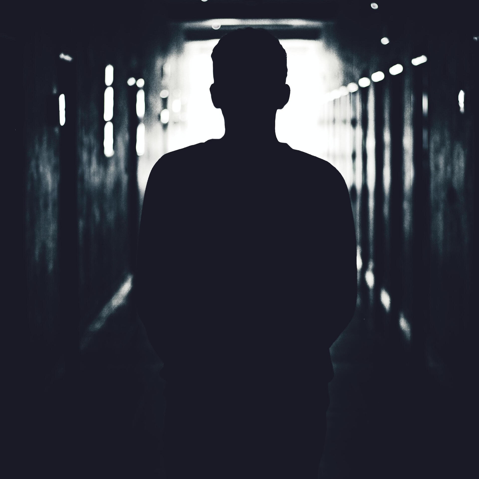 Silhouette of athlete walking through tunnel toward light — symbolic of inner journey and mental resilience
